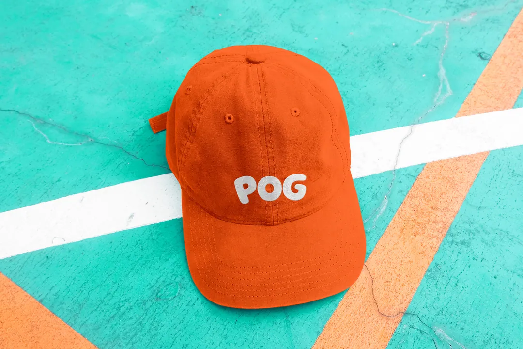 Orange cap with the POG wordmark on a court