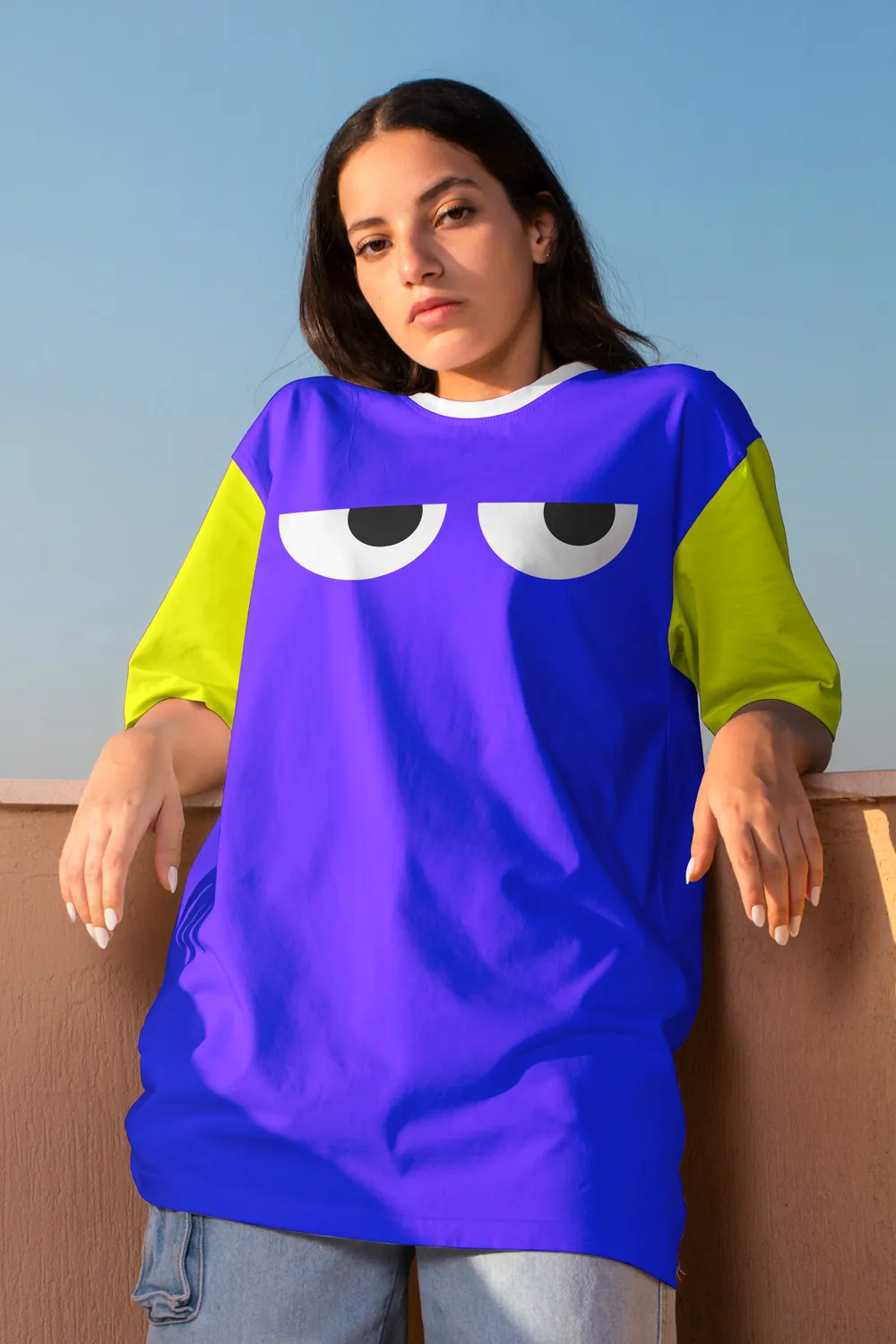 Model in an oversized violet tee with sleepy eyes on the chest